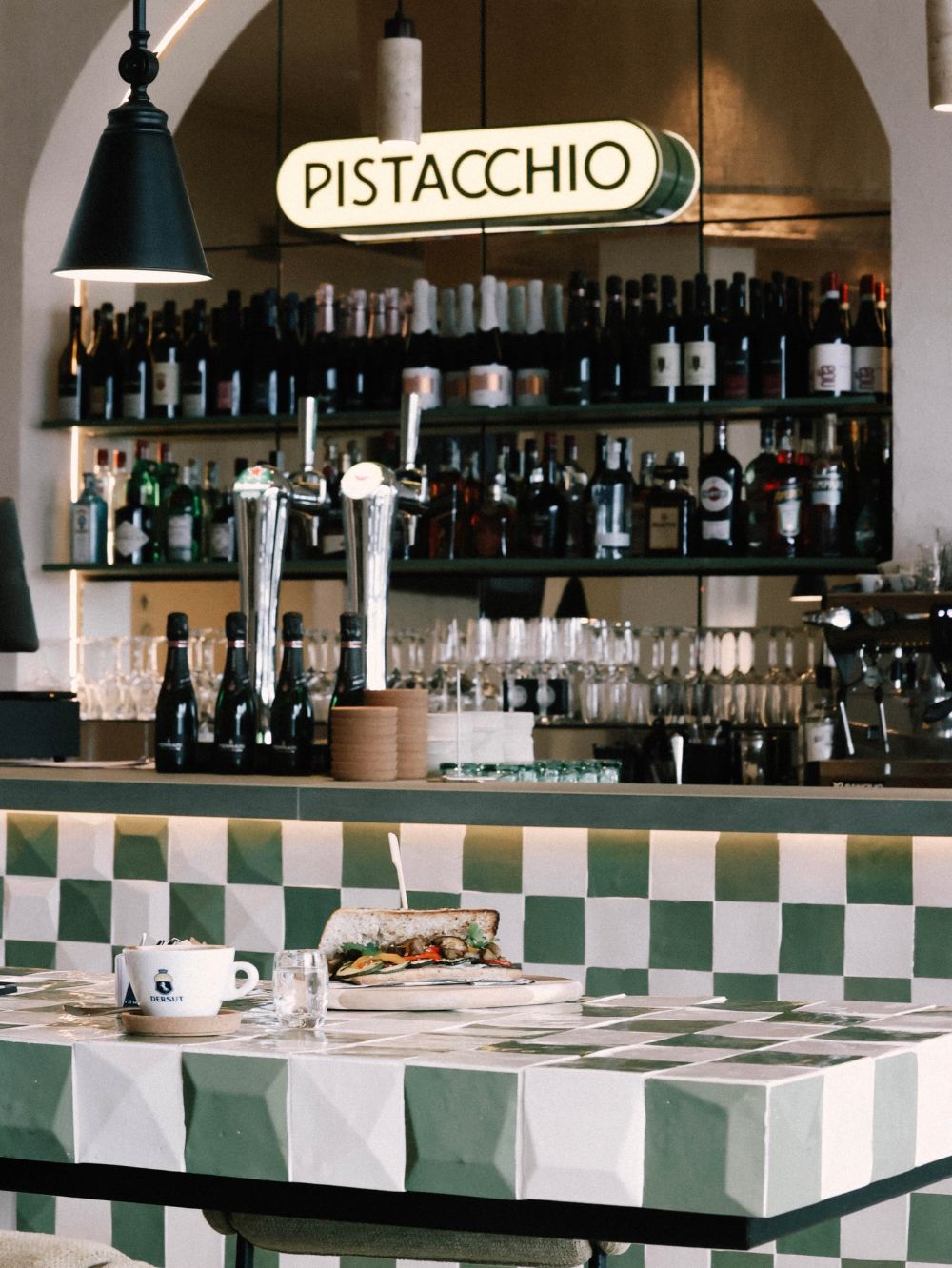 Bar with the neon Pistacchio sign and checkerboard tables